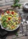 Pearl barley with seasonal garden vegetables in pan on wooden background, top view. Zucchini, sweet pepper, squash and barley stew Royalty Free Stock Photo