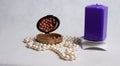 Pearl beads, a box of rouge and purple square candle