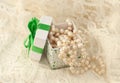 Pearl beads falling out of the gift box on a lacy surface Royalty Free Stock Photo