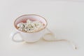 Pearl beads in a porcelain cup on a white background