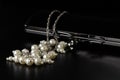 Pearl beads with a velvet black clutch on the table Royalty Free Stock Photo