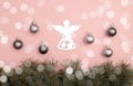 Pearl Christmas balls and figure of angel on the pink background with pine tree branches Royalty Free Stock Photo