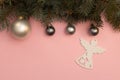 Pearl Christmas balls and figure of angel on the pink background with pine tree branches Royalty Free Stock Photo