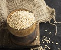 Pearl dry cereal in a vintage wooden bowl on a plain dark background for text placement and advertising. Selective focus Royalty Free Stock Photo