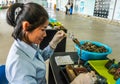 Pearl farm worker opens shell just enough to insert hard-shell bead, mantle tissue from oyster that has produced quality peal