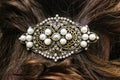 Pearl and filagree hair clasp in beautiful long reddish brown hair - close up Royalty Free Stock Photo