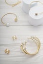 pearl golden bracelets and rings on white wooden background Royalty Free Stock Photo