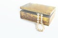 Pearl necklace, beads in antique metallic vintage casket on white background. Oldfashioned decoration from grandma`s jewelry box Royalty Free Stock Photo
