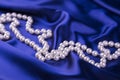 Pearl necklace on dark blue satin fabric Royalty Free Stock Photo