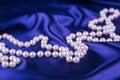 Pearl necklace on dark blue satin fabric Royalty Free Stock Photo