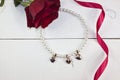 Pearl necklace with golden hearts on white wood Royalty Free Stock Photo