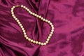 Pearl necklace on purple satin fabric background Royalty Free Stock Photo