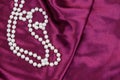 Pearl necklace on purple satin fabric background Royalty Free Stock Photo