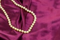 Pearl necklace on purple satin fabric background Royalty Free Stock Photo