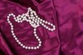 Pearl necklace on purple satin fabric background Royalty Free Stock Photo