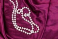 Pearl necklace on purple satin fabric background Royalty Free Stock Photo