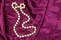 Pearl necklace on purple satin fabric background Royalty Free Stock Photo
