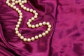 Pearl necklace on purple satin fabric background Royalty Free Stock Photo