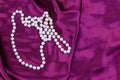 Pearl necklace on purple satin fabric background Royalty Free Stock Photo