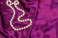 Pearl necklace on purple satin fabric background Royalty Free Stock Photo