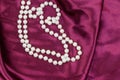 Pearl necklace on purple satin fabric background Royalty Free Stock Photo