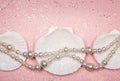 Pearl necklace and seashells on glitter pink background Royalty Free Stock Photo