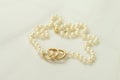 Pearl necklace with two golden rings Royalty Free Stock Photo
