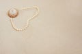 Pearl necklace on white fine sand with sea shell. Luxury resort, ocean or sea wedding concept Royalty Free Stock Photo