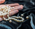 Pearl necklace on the woman's hand Royalty Free Stock Photo