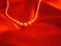 Pearl necklace jewelry on red satin background for valentines day Royalty Free Stock Photo