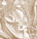 Pearls and nacreous beeds on silk as wedding background. In Sepi Royalty Free Stock Photo