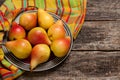 Pears on the dish and cloth on the old wood backing