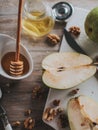 Pears, honey in a jar and nuts on a wooden table