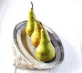 Pears on a plate, napkin on a white wooden background Royalty Free Stock Photo