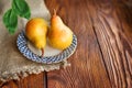Pears in a plate, top view. Wooden background with textiles. ripe organic pears close-up with leaves Royalty Free Stock Photo