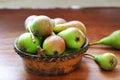 Pears in rustic clay dish on wooden table