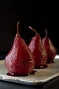 Pears in wine. Row of raditional dessert pears stewed in red win