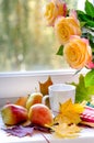 Pears and yellow roses with maple leafs near window