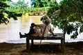 Peasant man sitting with his grandson on the banks of the river Royalty Free Stock Photo