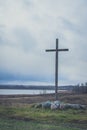 Peasant wooden cross on the mountain near the river bank, lake.