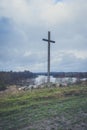 Peasant wooden cross on the mountain near the river bank, lake.