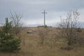 Peasant wooden cross on the mountain near the river bank, lake.