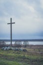 Peasant wooden cross on the mountain near the river bank, lake.