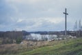 Peasant wooden cross on the mountain near the river bank, lake.