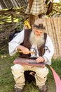 Peasant working on a leather belt