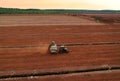 Peat Harvester Tractor on Collecting Extracting Peat. Mining and harvesting peatland. Area drained of the mire are used for peat