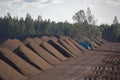 Peat harvesting. Field with piles of harvested peat