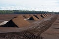 Peat harvesting. Field with piles of harvested peat