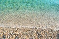 Pebble beach with azure sea water texture Royalty Free Stock Photo