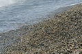 pebble beach washed by sea waves, small and various stones forming the shore